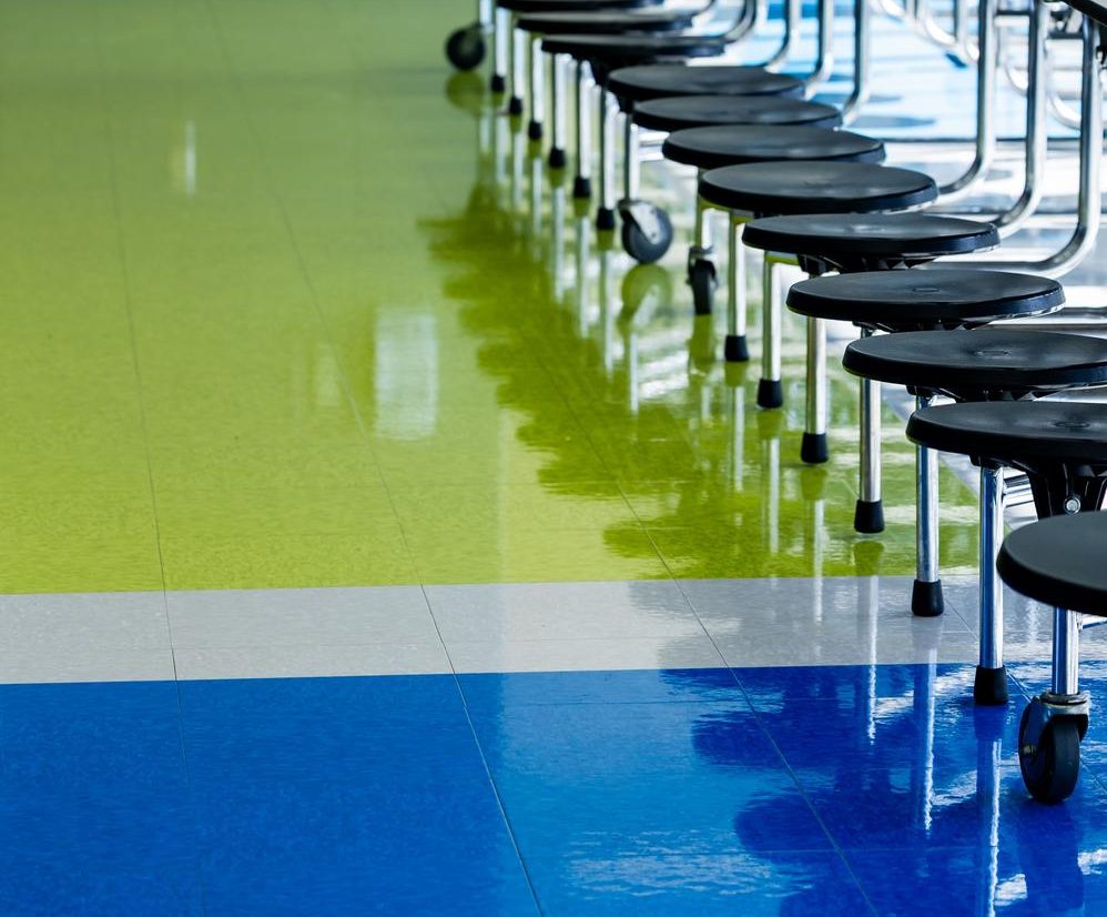 Glossy solid color epoxy floor in green, white, and blue sections